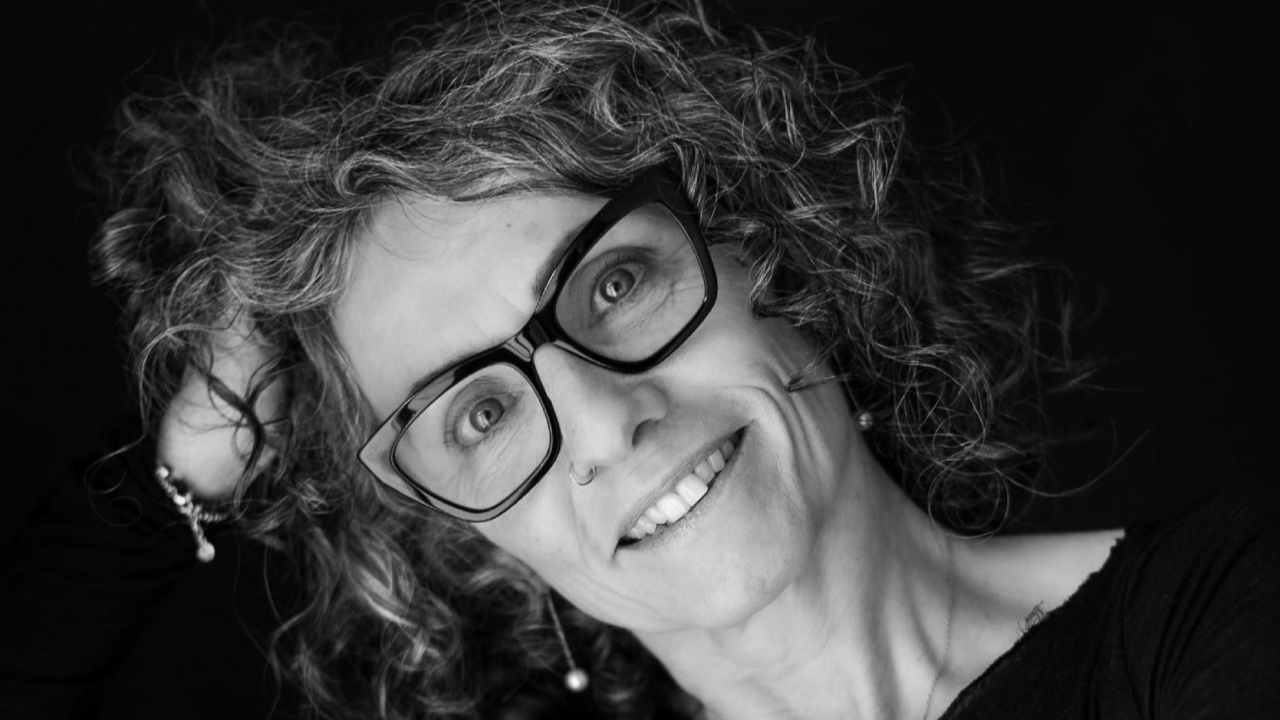 Mitglied vom FrauenRaum Netzwerk Marietta Kuonnen von freeinside Coaching lächelt in die Kamera, die eine Hand in ihren Haaren.