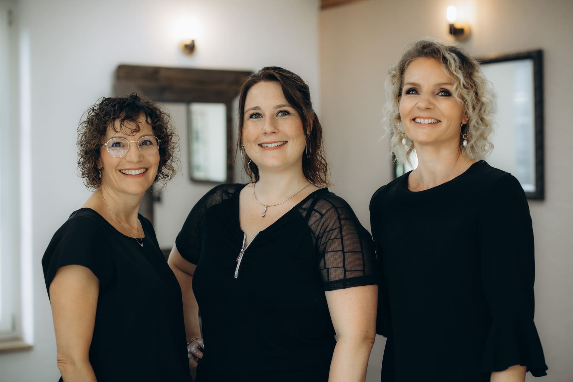 Das Team von Coiffeur Esprit, insgesamt 3 Frauen tragen alle Schwarze Oberteile und lächeln in die Kamera.