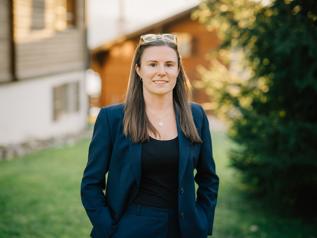 Mitglied vom FrauenRaum Netzwerk Andrea Hauenstein trägt einen dunkelblau grünen Anzug und schaut in die Kamera.