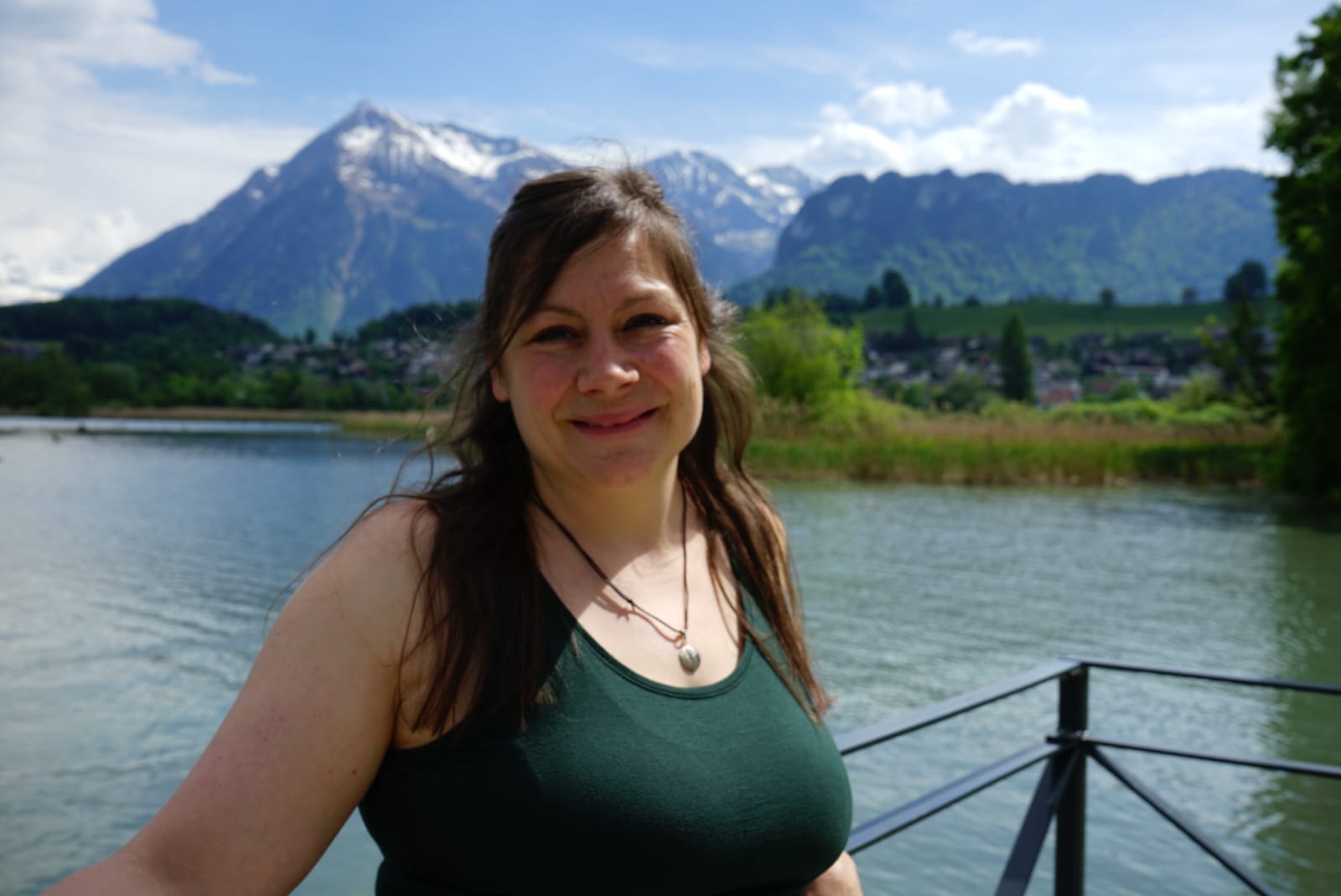 Mitglied vom FrauenRaum Netzwerk Simone Gasser lächelt in die Kamera, hinter ihr der Thunersee und die Berge.